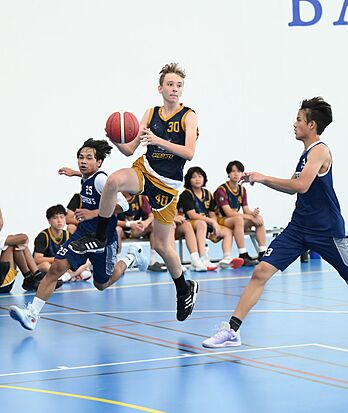 Brighton College Vibhavadi pupils playing basketball, developing leadership and teamwork through physical education.