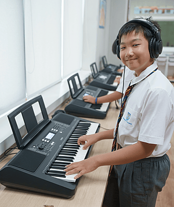 Boy enjoying music class at Brighton College Vibhavadi, a premium international school in Bangkok with a strong performing arts programme.