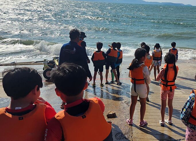  Pupil exploring the marine environment on a sea trip with Brighton College Vibhavadi, promoting hands-on learning outside the classroom. 