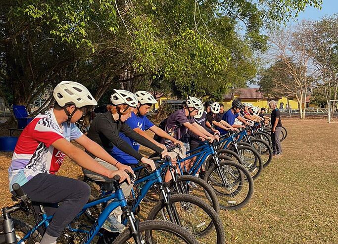 Pupils biking in an open field during a school trip, experiencing self-growth and adventure through outdoor education at Brighton College Vibhavadi. 