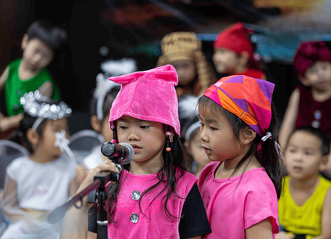  Two pupils singing on stage during a performance at Brighton College Vibhavadi, where performing arts support confidence and expression. 