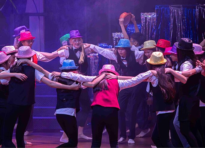  Pupils dancing in a group at Brighton College Vibhavadi, nurturing creativity and confidence through performing arts. 