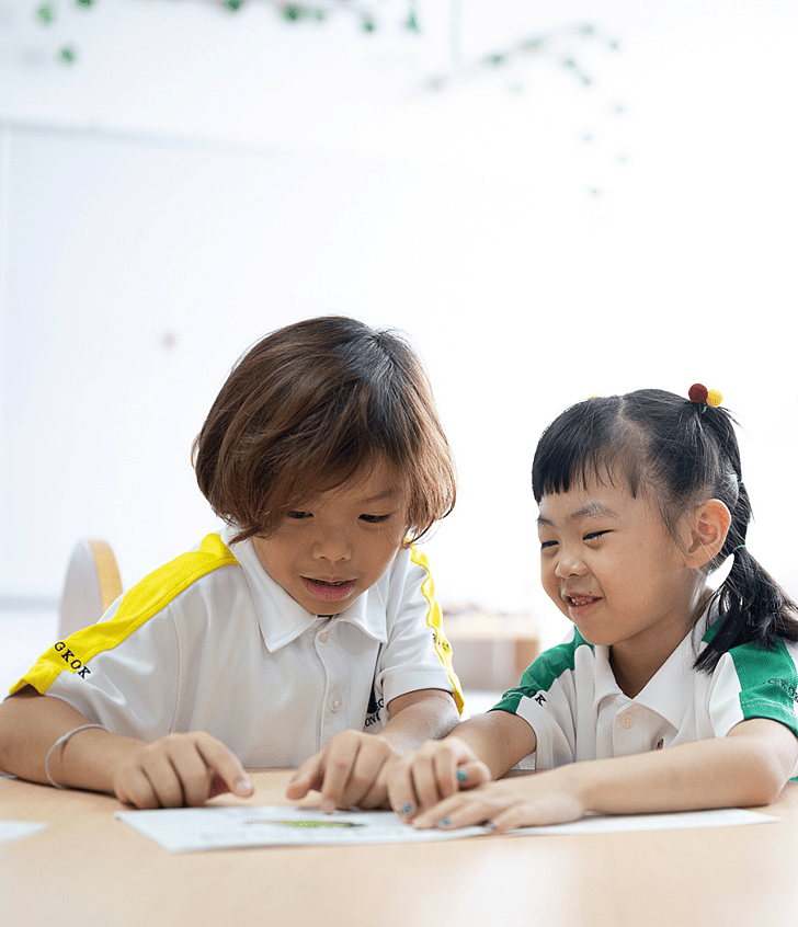  Two Brighton College Vibhavadi pupils reading and laughing together in class 