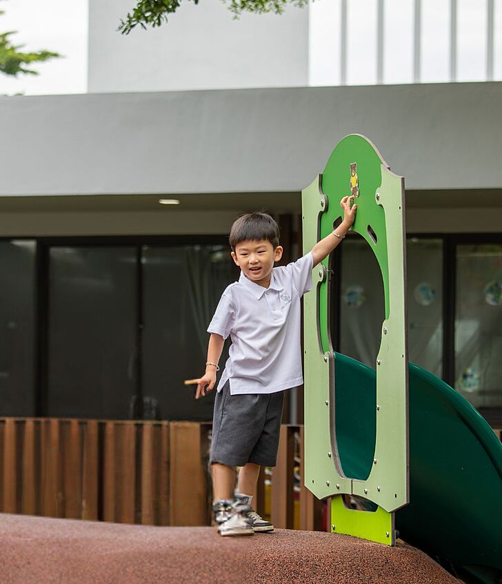  Pupil smiling at the playground of Brighton College Vibhavadi, enjoying outdoor time in a green and sustainable school environment. 