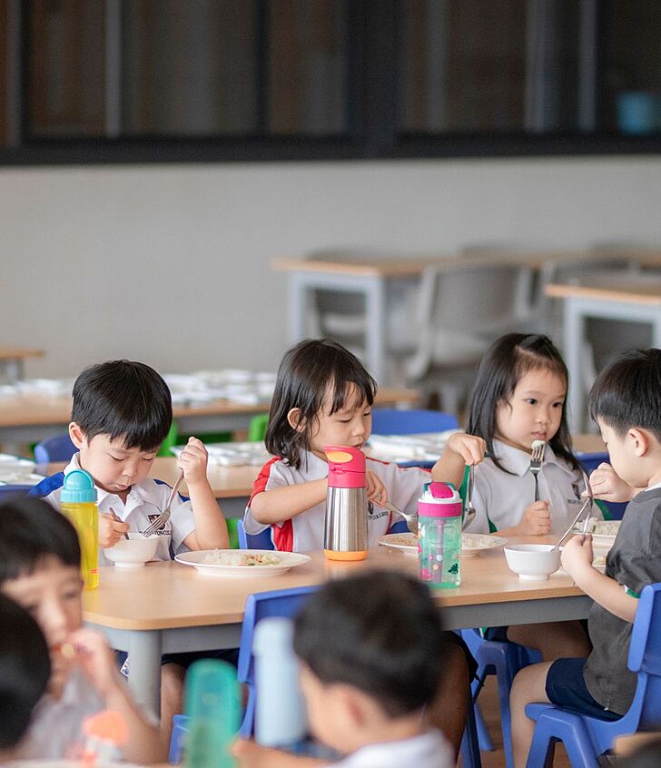  Pupils enjoying lunch in the cafeteria at Brighton College Vibhavadi, part of a supportive and balanced school environment in Thailand. 
