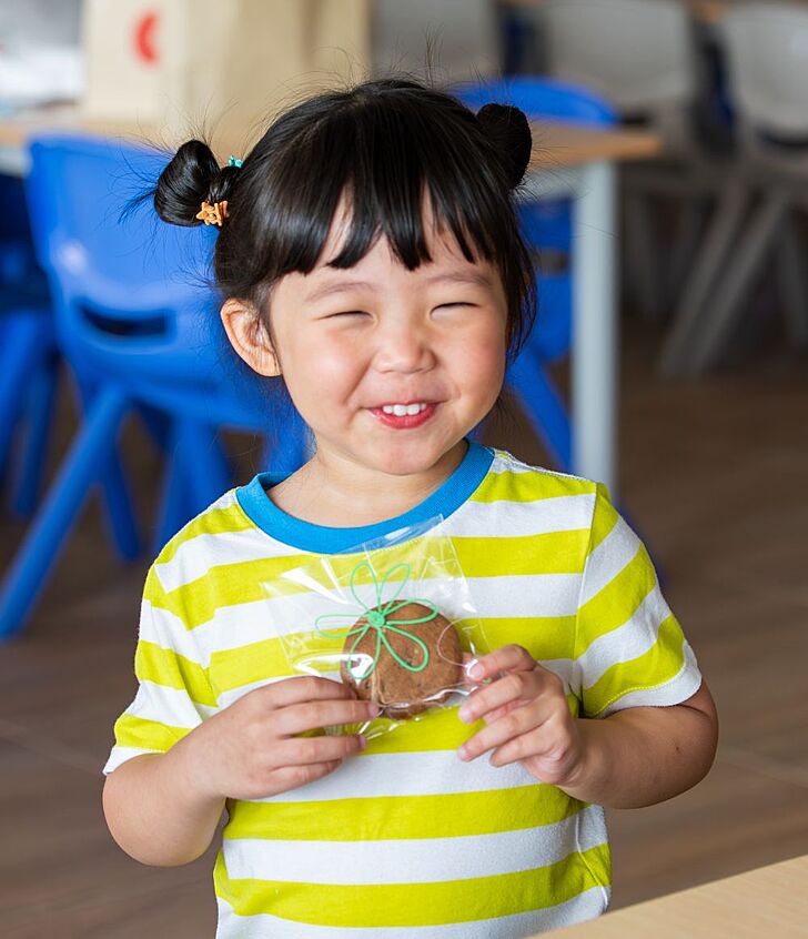  Pupils smiling while holding cookies at Brighton College Vibhavadi during a community event that fosters kindness and social responsibility. 