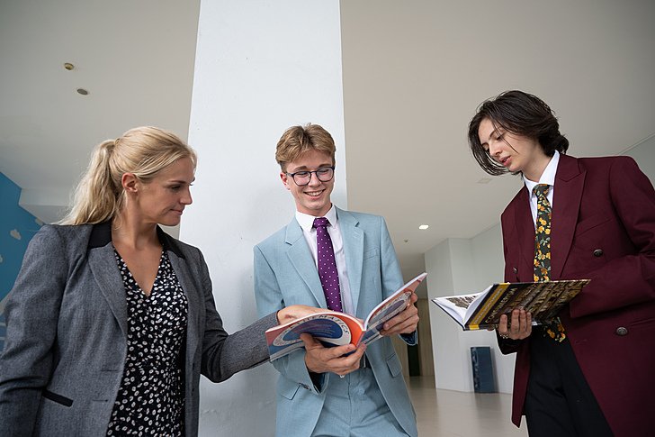  Sixth Form pupils engaging in discussion with a teacher at Brighton College Vibhavadi, where mentoring and personalised support are key. 
